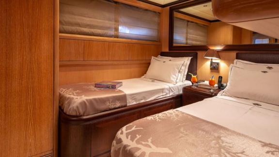 Cosmos yacht’s twin cabin offers cozy comfort with soft lighting and wooden charm.