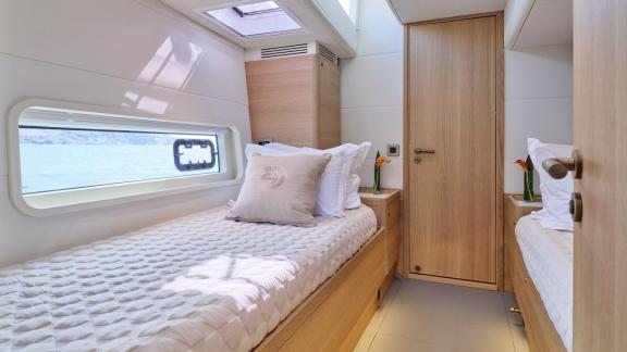 Off Lavrion the 3 cabin 6 guest Omikron Yachts OT 60 N ice featuring a bright twin cabin with two separate beds.