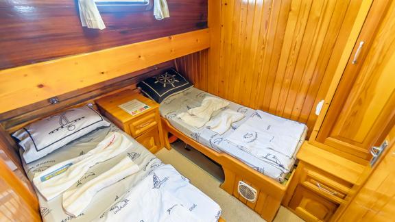 Practical cabin with two single beds and wooden walls. Perfect for comfortable overnight stays at sea.