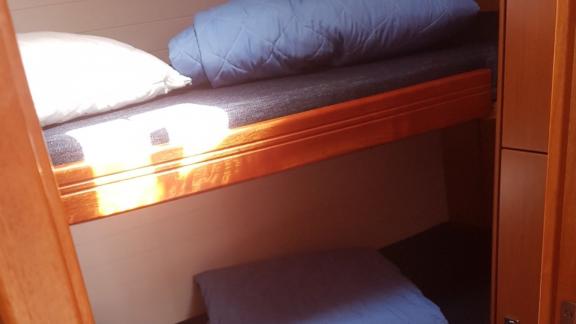 In der Kabine der Segelyacht Vivi befinden sich Etagenbetten, die mit Kissen und Decken ordentlich arrangiert sind.