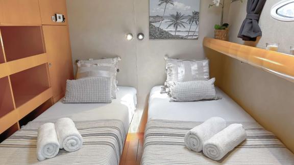 Bright cabin with two single beds on catamaran Zorba, ideal for comfortable overnight stays at sea.