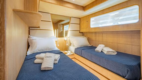 The comfortable twin cabin of Opera yacht stands out with stylish decor and cozy beds.