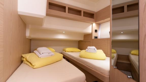 The twin bedroom on the motor yacht Ocean Dreamer features two beds and modern storage spaces.