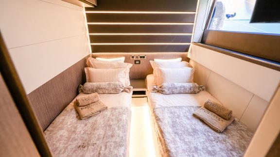 Schlafzimmer auf der Yacht FG Star mit zwei Einzelbetten und moderner Beleuchtung.