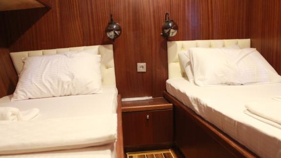 Comfortable twin-bed cabin on Gulet Life is Life featuring warm wood decor and cozy lighting.