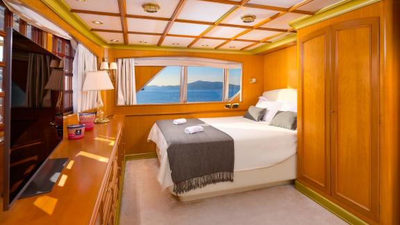 Trogir açıklarında yer alan bu misafir kamarası deniz manzaralı pencereleri ve sıcak ahşap tonlarıyla dikkat çekiyor.