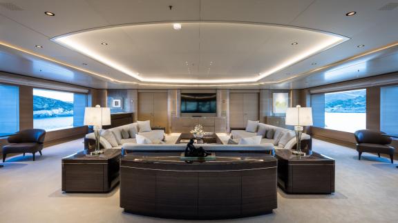 Luxurious lounge on the Opari yacht with elegant furnishings, large windows, and sea views.