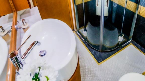 На яхте Ferretti 780 Orlando L ванная с круглой раковиной и душевой кабиной со стеклянными дверцами.