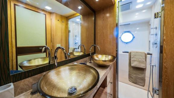 Monte Carlo 86 Giorgio’s bathroom boasts gold basins and a bright spacious shower area.