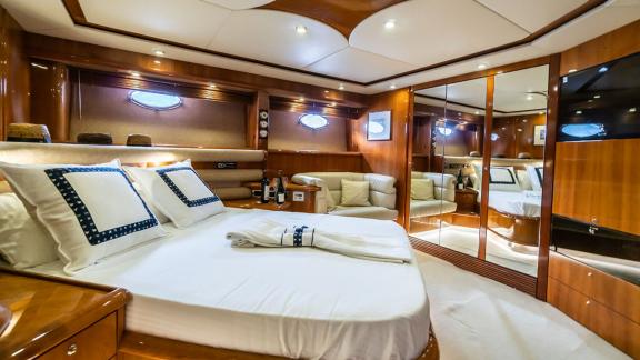 Comfortable bedroom of the Edition yacht, featuring a large mirror and sea view windows.