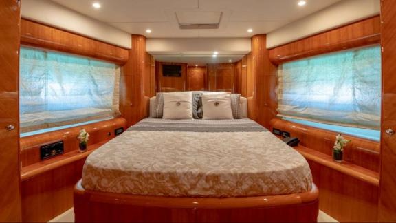 The luxurious guest cabin of the Venus Secrets yacht offers a comfortable stay with a large bed and a cozy ambiance.