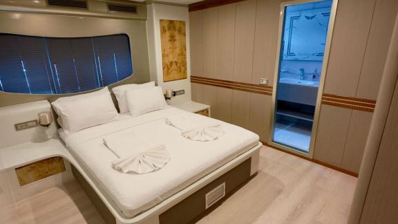 The guest cabin of Angelo 3 is equipped with a stylish bed and a bathroom.