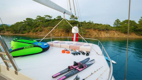 Upper deck of the gulet Vega with sun loungers, water sports equipment and calm water in the background.