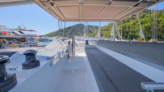 Der Katamaran Kokopelli liegt im Hafen von Göcek vor Anker, mit Blick auf das Steuer und das Oberdeck.