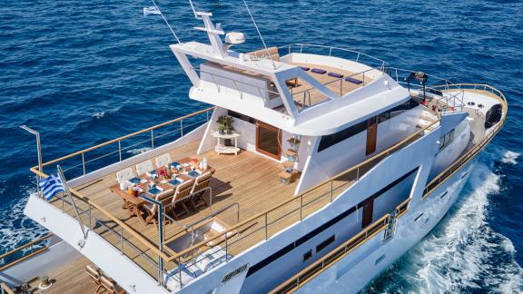 Elegant dining area on the upper deck of the motor yacht Wide Liberty on the open sea.