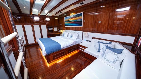 Schlafzimmer in modernem Design. Sie können ein großes Bett und ein Sofa sehen. Kann als Zustellbett genutzt werden