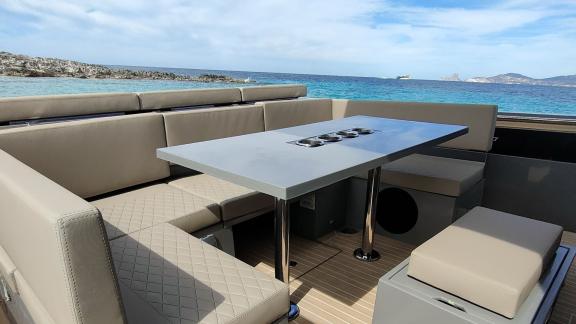 The spacious seating and dining area on the aft deck of motor yacht Alegria offers comfort with a sea view.