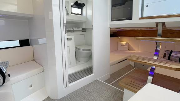 The bright and stylish interior living area of motor yacht Alegria features comfortable seating and a modern bathroom.