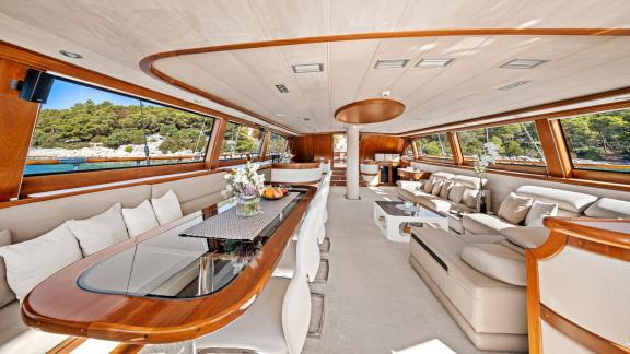 Der Salon der Gulet Alessandro 1 mit großen Fenstern bietet eine stilvolle und komfortable Wohnatmosphäre.