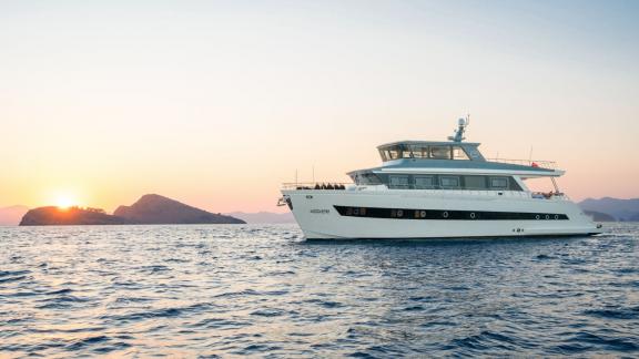 Der Trawler Alessandro gleitet bei Sonnenuntergang durch Göceks ruhige Gewässer – ideal zum Chartern.