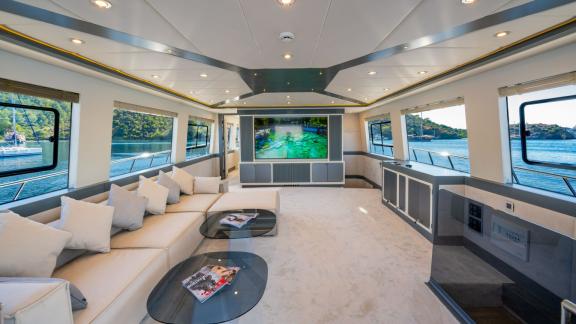 Die Alessandro bietet einen eleganten Salon mit Panoramafenstern und großem TV – ideal für Yachtcharter in Göcek.