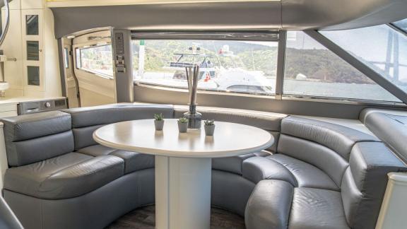 The round table and cozy seating area in the interior of Alfa F yacht offer comfort with a scenic view.