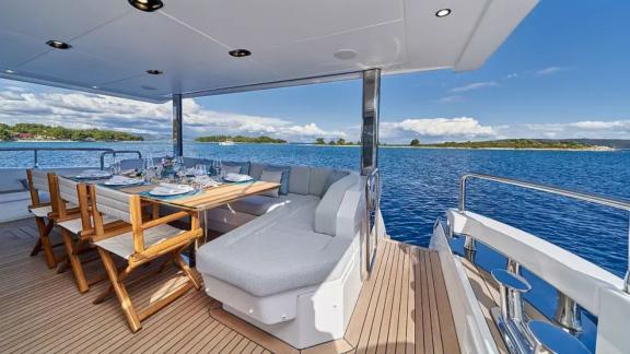 На кормовой палубе Azimut Grande 27 сервирован стол с видом на море.