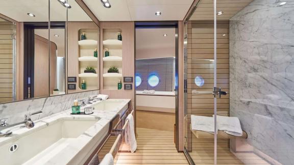 Ванная Azimut Grande 27 у Кастелы оформлена мрамором и зеркалами для комфорта.