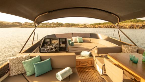 Auf dem Oberdeck der Motoryacht Ammonite befindet sich ein gemütlicher Sitzbereich mit Kissen.