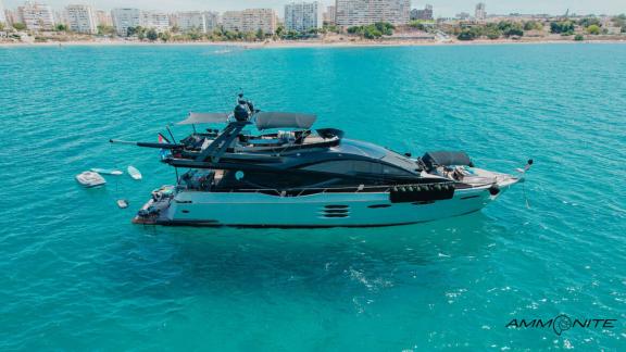 The Ammonite motor yacht is floating in a calm bay.