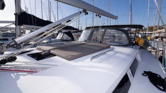 The foredeck of the yacht Anse offers a comfortable sunbathing area and is anchored in the marina.