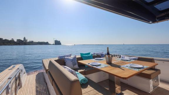 Among Cannes yacht charter options Arlias motor yacht shows aft deck with dining setup and sea view.