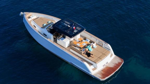 Among Cannes yacht charter options Arlias motor yacht shows aft lounge with table and sunbed area.