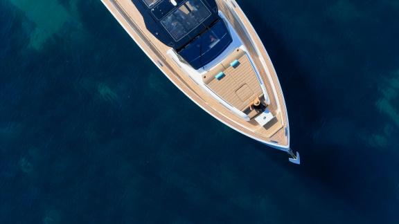 Among Cannes yacht charter options Arlias motor yacht shows bow sunbathing area and clear sea view.