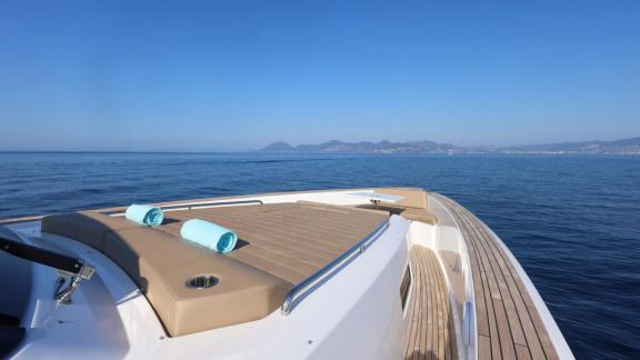 Among Cannes yacht charter options Arlias motor yacht shows front deck with sunbed and open sea view.