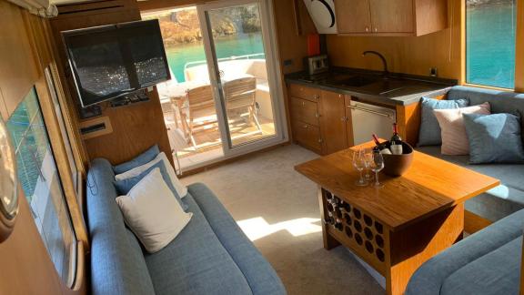 The saloon of the trawler yacht Atıl in Göcek features a comfortable seating area and a kitchen.