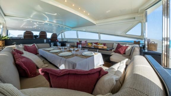 Inside the motor yacht Aya One, an elegantly set dining table and a spacious seating area are featured.