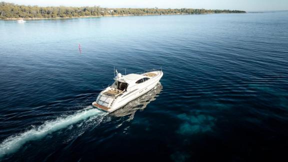 Among Cannes daily yacht rental options Best Mountain is seen from distance cruising calmly in open sea.
