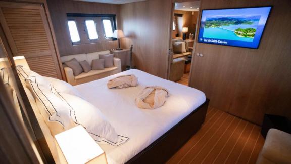 Among Cannes daily yacht rental options Best Mountain cabin shows bed and TV for comfortable stay.