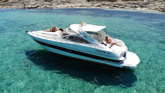 Motor yacht Black Ball is perfectly anchored near turquoise shores, ideal for relaxation.