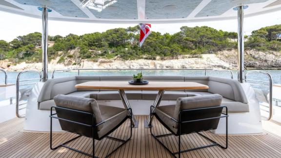 Among Spain yacht charter options Blue Infinity One shows aft deck with table and seating area.