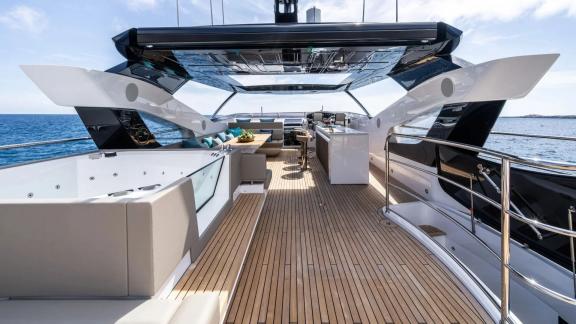 Among Spain yacht charter options Blue Infinity One shows upper deck with lounge and bar area.