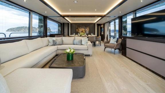 Among Spain yacht charter options Blue Infinity One shows lounge with sofa and dining space.