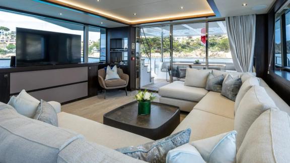Among Spain yacht charter options Blue Infinity One shows salon with sofas and sea view.