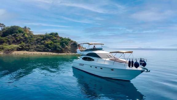 Motor yacht Blue My Story anchored in calm waters, showcasing a stylish and elegant exterior.