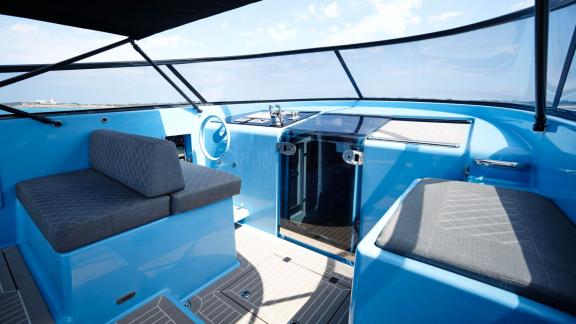 The front section of the Blue Steel motor yacht features a seating area and helm station.