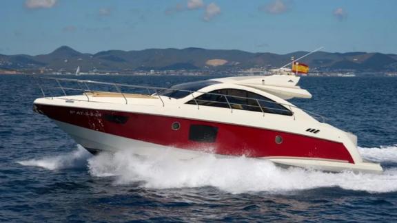 The Breathe motor yacht stands out with its red hull while cruising at high speed on the open sea.