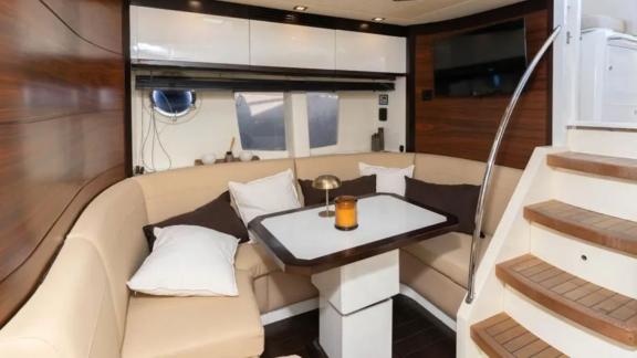 The interior of motor yacht Breathe features a cozy dining nook with soft cushions and an elegant table.