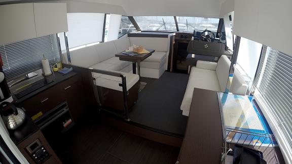 The living room on the motor yacht Brigadoon features modern furniture, a dining table, and a spacious seating area.