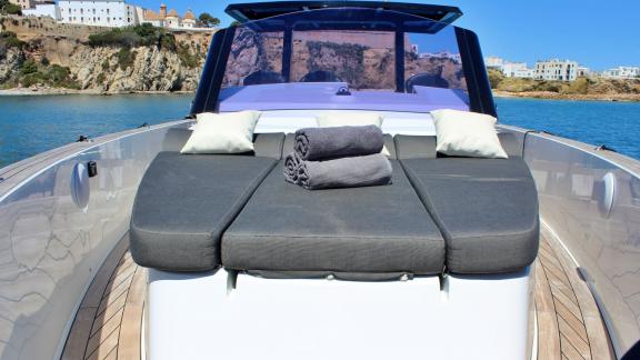 The foredeck of the motor yacht Celebrate features a spacious sunbathing area with cushions for comfort.